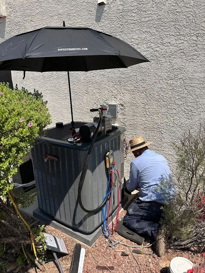 HVAC technician performing outdoor AC maintenance in Edgemoor