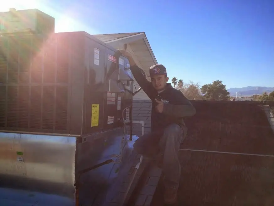 HVAC technician performing Heat Pump Repair on a rooftop unit in Edgemoor